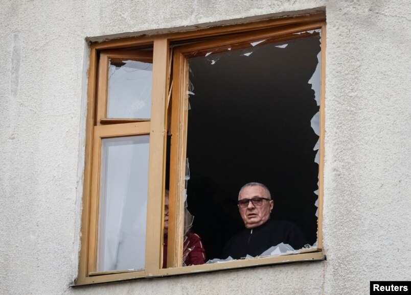 Një banor i Harkivit shikon nga një dritare e thyer nga sulmet e Rusisë në Ukrainë, më 25 mars 2026.