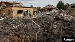 Люди стоять біля зруйнованих житлових будинків на місці російського ракетного удару, Покровськ, Донецька область Україна, 24 червня 2024 року