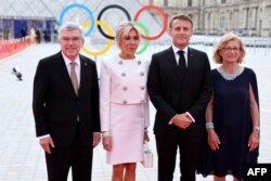 Președintele Comitetului Internațional Olimpic, Thomas Bach (s), soția sa Claudia Bach, președintele francez, Emmanuel Macron (al doilea din dreapta), și soția sa, Brigitte Macron, la dineul de gală găzduit de CIO și președinția franceză înainte de JO. 25 iulie 2024.