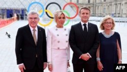 Președintele Comitetului Internațional Olimpic Thomas Bach (s), soția sa Claudia Bach, președintele francez Emmanuel Macron (al doilea din dreapta) și soția sa Brigitte Macron, la dineul de gală găzduit de CIO și președinția franceză,înainte de JO. 25 iulie 2024.