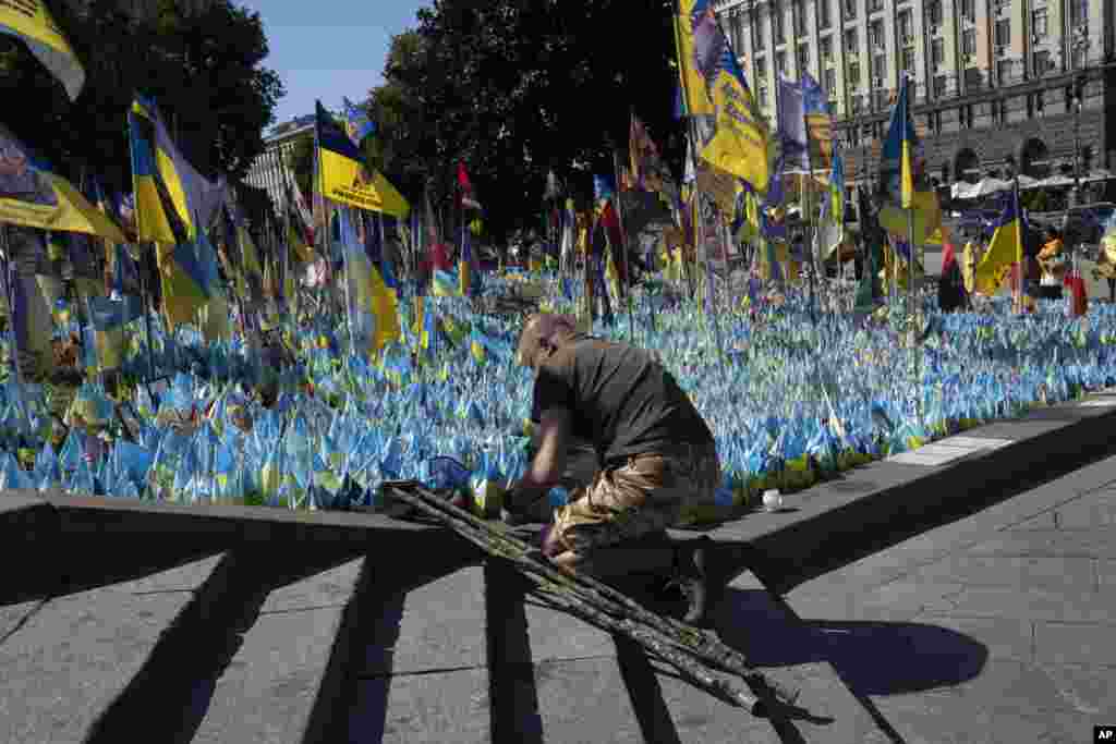  A veteran pays his respect at a makeshift memorial for fallen Ukrainian soldiers on Ukrainian Independence Day in Kyiv. &nbsp; 