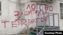 The graffiti on the wall of Lev Ponomaryov's office saying "Hide-out for the defender of terrorists"