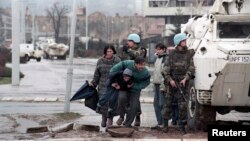 Stanovnici Sarajeva skrivaju se od snajpera iza oklopnog vozila Zaštitnih snaga UN-a (UNPROFOR), 1993. godine.