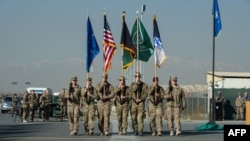 The International Security Assistance Force (ISAF) color guard marches during the ISAF Joint Command (IJC) and XVIII Airborne Corps color lowering and casing ceremony in Kabul.
