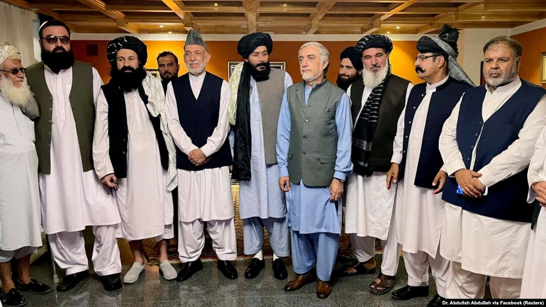 Former Afghan President Hamid Karzai (fifth left) and the ousted government's peace envoy, Abdullah Abdullah (fifth right), meet with members of the Taliban after the militants seized power in Kabul.