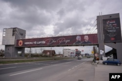 Një baner me mbishkrimin "heronj të luftës" dhe me fotografitë e Hashim Thaçit e Kadri veselit shfaqet në Prishtinë, prill 2023.