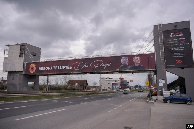 Një baner me mbishkrimin "heronj të luftës" dhe me fotografitë e Hashim Thaçit e Kadri veselit shfaqet në Prishtinë, prill 2023.