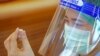 Қытайдың Sinovac Biotech компаниясы коронавирусқа қарсы шығарған вакцинаны шприцпен сорып тұрған адам. Көрнекі сурет.