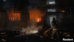 Ресей күштерінің әуе шабуылы салдарынан жанған отты сөндіріп жатқан адам. Украина, Сумы облысы, 11 сәуір, 2026 жыл.