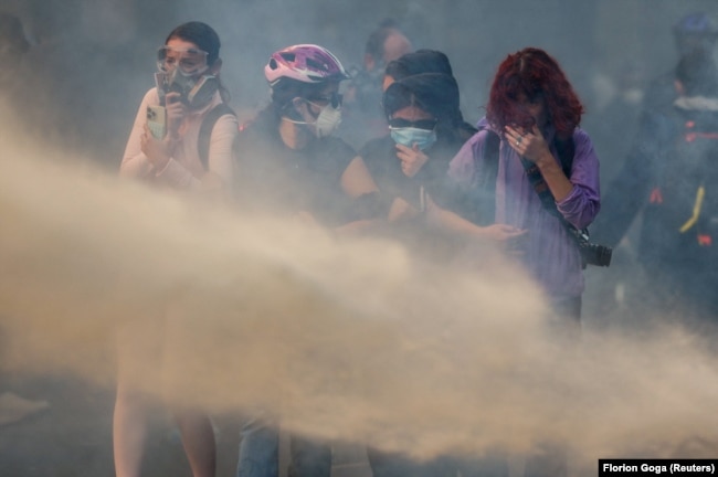 Protestuese duke reaguar pas spërkatjes nga një top uji gjatë protestës antiqeveritare të 20 tetorit 2026 në Tiranë.