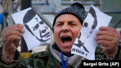 Un demonstrant la Kieva cu portretul lui Viktor Ianukovici în 2013