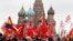 Russia -- Russian Communist Party supporters carry flags at the Red Square, with St. Basil's Cathedra seen in the background, as they take part in a wreath-laying ceremony at Vladimir Lenin's mausoleum to mark the October Revolution's centenary in Moscow,