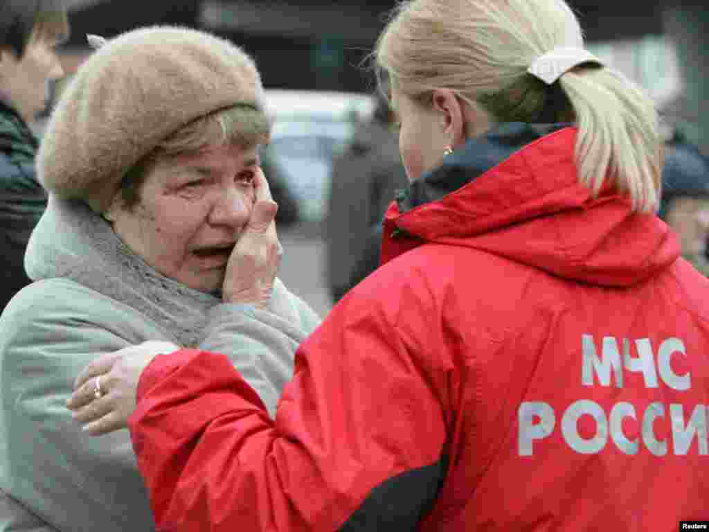 A woman cries while standing next to an Emergencies Ministry official near Park Kultury metro station.