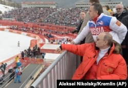 Russian President Vladimir Putin (foreground) and then-Sports Minister Vitaly Mutko (top) in Sochi in 2014