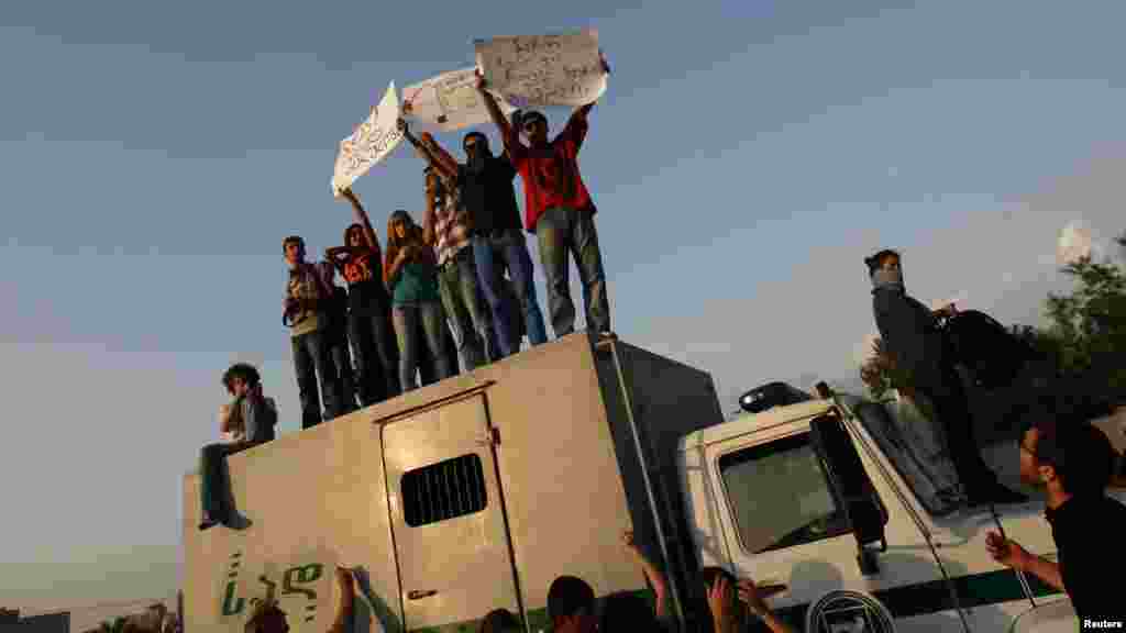 Georgian students stand on a prison-transfer vehicle during a protest in Tbilisi. (Reuters/David Mdzinarishvili)
