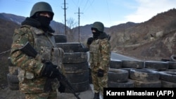 NAGORNO-KARABAKH -- Armenian soldiers stand guard at a checkpoint on the road leading to Kalbacar, near the village of Charektar, November 25, 2020