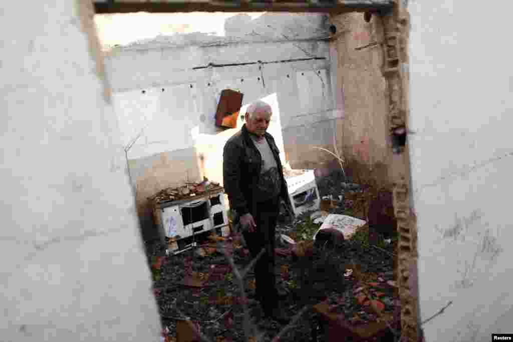 Sava Knezevic, 65, walks through his house in the Croatian town of Knin, destroyed during the Balkan wars of the early 1990s.