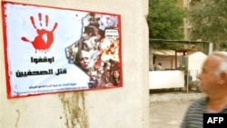 In Baghdad, a poster reading "Stop Killing Journalists" bears photographs of media personnel killed in the line of duty.