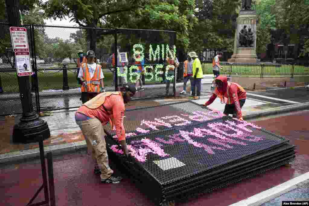 Workers remove an anti-scaling fence around Lafayette Park, Thursday, June 11, 2020, near the White House in Washington, that was erected for protests over the death of George Floyd, a black man who was in police custody in Minneapolis. Floyd died after being restrained by Minneapolis police officers.