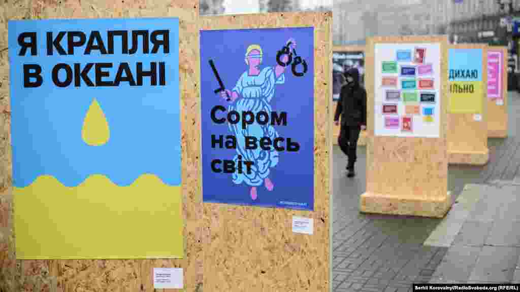 Учасники віче стоять між плакатами часів Майдану, виставку яких було організовано до другої річниці Революції гідності