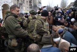 Глава "ДНР" Захарченко рядом с пленными в Донецке. Пленных солдат провели через город и поставили на колени в том месте, где попал под артобстрел троллейбус, после этого местным разрешили закидать пленных снежками и бутылками