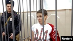 Ukrainian pilot Nadia Savchenko looks out from a defendant's cage during a hearing in Moscow on February 10.