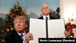 Donald Trump arătînd documentul care proclamă Ierusalimul capitală recunoscută a Israelului.