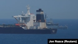 A British Navy patrol vessel guards the oil supertanker Grace 1 in Gibraltar territorial waters.