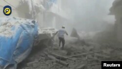 На кадре из видео член сил гражданской обороны Сирии в квартале сирийского города Алеппо после предполагаемой химической атаки. 6 сентября 2016 года.