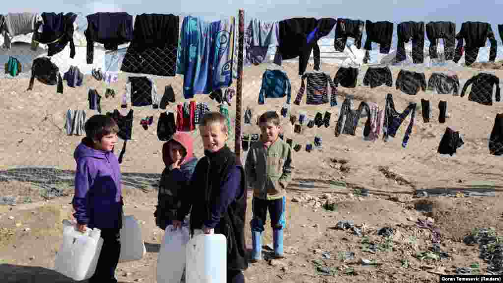 Djeca drže spremnike za vodu u kampu Al-Hol, 8. siječnja 2020. Ovdje se najmlađi igraju po blatnjavim stazama i lokvama punim smeća.