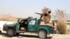  An Afghan policeman aims a machine gun at Taliban positions on the outskirts of the southern Afghan city of Kandahar.