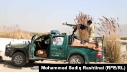  An Afghan policeman aims a machine gun at Taliban positions on the outskirts of the southern Afghan city of Kandahar.