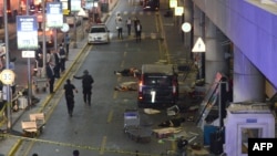 Раненые лежат на земле у входа в терминал