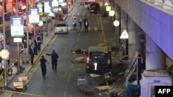 Injured people lie on the ground next to a terminal, after two explosions followed by gunfire hit the airport of Ataturk in Istanbul on June 28.