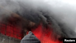 A firefighter attempts to extinguish a fire at a factory after what activists said was shelling by forces loyal to Syria's President Bashar al-Assad in Aleppo on February 8.