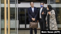 Majid Taheri (solda) aeroportda həyat yoldaşı və XİN rəsmisi tərəfindən qarşılanır