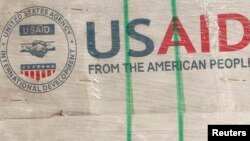 Philippines -- The shadow of a Philippine Army personnel is cast on boxes of relief items from US Agency for International Development (USAID) for the victims of super typhoon Haiyan, at Villamor Air Base in Manila November 13, 2013