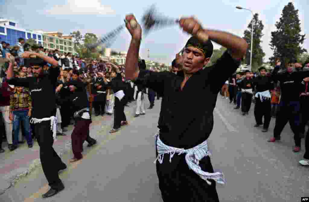 Pakistani Shi'ite Muslims flagellate themselves during a religious procession to mark the Day of Ashura, which commemorates the anniversary of the death of the Prophet Muhammad's grandson Imam Hussain in 680 A.D. (AFP/Farooq Naeem)