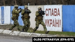 Украинские военные на фоне лозунга "Слава Украине"