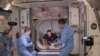 Астронавты на пороге переходного люка между станцией и кораблём "Крю Дрэгон"
