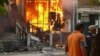 Men walk past a burning building during the 2010 violence in the Kyrgyz city of Osh that left hundreds dead. 