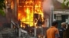 Men walk past a burning building in Osh on June 11, when at least 12 people died in the unrest.