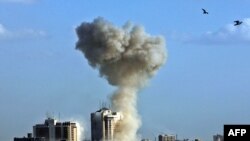 Smoke rises into the sky following an explosion in the area near Palestine Hotel in central Baghdad on June 25, one of at least three deadly explosions.