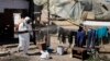 Radnik dezinfikuje garderobu i prostor u jednom od romskih naselja tokom pandemije korona virusa