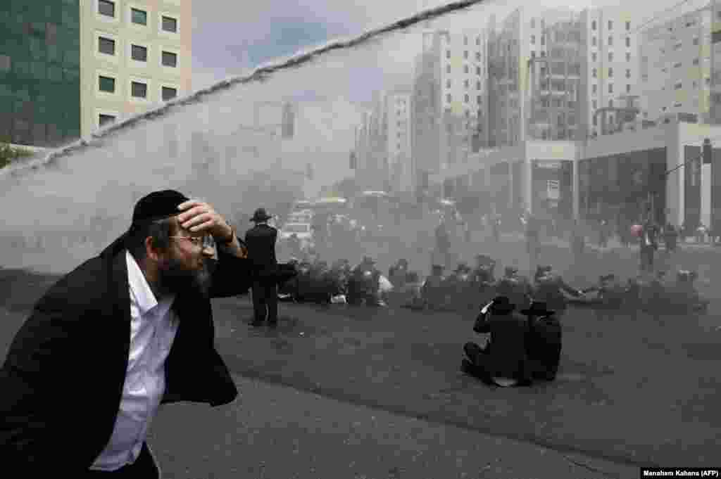 Ultra-Orthodox Jews, demonstrating against the annual Gay Parade in Jerusalem, are sprayed with water cannons by Israeli security forces on August 2. (AFP/Menahem Kahana)