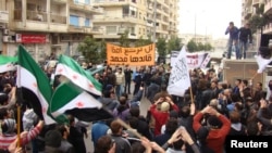 Antigovernment protesters in Syria wave flags and carry coffins during the funeral for two protesters killed in clashes in Homs on January 31.