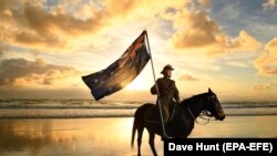 Chris Kennedy and his horse Chaos pose for photos on Currumbin Beach ahead of Australian and New Zealand Army Corps (ANZAC) Day on the Gold Coast of Australia on April 24. Anzac Day, held annually on April 25, commemorates the people who lost their lives or served in wars and conflicts. (epa-EFE/Dave Hunt)