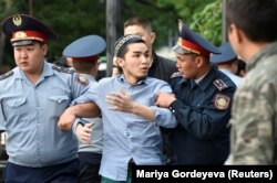 Алматы полициясы алаңда жүрген адамды ұстап әкетіп барады. 12 маусым 2019 жыл.