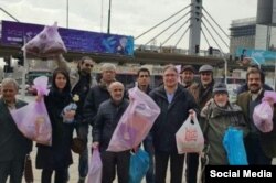 former Tehran University chancellor Mohammad Maleki and former hard-line columnist Mohammad Nurizad pose with colleagues during their trash-collecting protest on February 2.