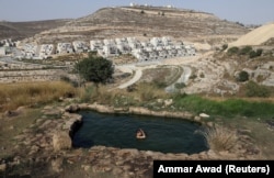 На окраине Иерусалима молодой израильтянин плавает в бассейне с природной родниковой водой, 13 июля 2017 года